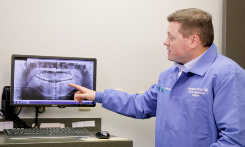 Dr Kittle reviews an x ray | greater michigan oral surgeons implant center